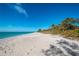 Beautiful beach scene with white sand, clear blue water, and lush greenery, perfect for relaxation at 1551 Beach Rd # 212, Englewood, FL 34223