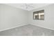 A bright, carpeted bedroom featuring a ceiling fan and a window at 1551 Beach Rd # 212, Englewood, FL 34223