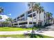 Exterior view of a multi-story condo building with tropical landscaping and covered parking at 1551 Beach Rd # 212, Englewood, FL 34223