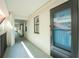 Hallway with unit 212 featuring a screened door, white walls, and a view of the building's architecture at 1551 Beach Rd # 212, Englewood, FL 34223