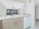 Bright kitchen with light countertops, modern appliances, and an open view into the living area with a balcony at 1551 Beach Rd # 212, Englewood, FL 34223