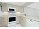 Well-lit kitchen featuring white appliances, neutral-toned cabinets, and light countertops with modern hardware at 1551 Beach Rd # 212, Englewood, FL 34223