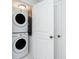A compact laundry area featuring a stacked washer and dryer and storage cabinets at 1551 Beach Rd # 212, Englewood, FL 34223