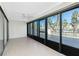 Bright living room boasts tile flooring and large sliding glass doors with tropical views at 1551 Beach Rd # 212, Englewood, FL 34223
