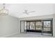 Spacious living room featuring ceiling fan and sliding glass doors with views to the outside at 1551 Beach Rd # 212, Englewood, FL 34223