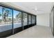 Bright living room boasts tile flooring and large sliding glass doors with tropical views at 1551 Beach Rd # 212, Englewood, FL 34223