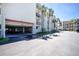 View of a parking garage at a condo building with tropical landscaping and ample parking space at 1551 Beach Rd # 212, Englewood, FL 34223