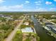 Stunning aerial view of waterfront homes along canals, showcasing boat docks and lush surroundings in a coastal community at 15850 Viscount Cir, Port Charlotte, FL 33981