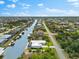 Picturesque aerial view of a neighborhood featuring canal-front homes, boat docks, and mature trees enhancing the landscape at 15850 Viscount Cir, Port Charlotte, FL 33981