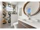 Bright bathroom with a modern sink, wood-trimmed mirror and decorative wallpaper at 15850 Viscount Cir, Port Charlotte, FL 33981