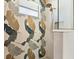 Close up of tiled shower with floral pattern and bronze shower head at 15850 Viscount Cir, Port Charlotte, FL 33981