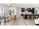 Stylish dining area with a modern light fixture, open to the kitchen and views of the outdoor living space at 15850 Viscount Cir, Port Charlotte, FL 33981