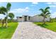 Charming home with a paved driveway and mature palm trees at 15850 Viscount Cir, Port Charlotte, FL 33981