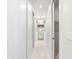 Hallway with marble floors, closet, and view into the main bathroom with tub and chandelier at 15850 Viscount Cir, Port Charlotte, FL 33981