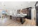 Open kitchen featuring a large island with seating, modern cabinets, and views of the dining area at 15850 Viscount Cir, Port Charlotte, FL 33981