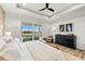 Bright main bedroom featuring tray ceiling, dresser, ceiling fan, and lanai access overlooking the canal at 15850 Viscount Cir, Port Charlotte, FL 33981