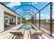 This screened-in pool area offers a tranquil oasis with relaxing chaise lounges and picturesque views of the waterfront at 15850 Viscount Cir, Port Charlotte, FL 33981