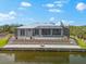 Stunning rear exterior view of waterfront home with a screened lanai, pool, and landscaped yard at 15850 Viscount Cir, Port Charlotte, FL 33981