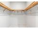 Empty walk-in closet featuring double wooden shelves on the sides with white walls and tile floor at 15850 Viscount Cir, Port Charlotte, FL 33981