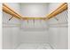Empty walk-in closet featuring double wooden shelves on the sides with white walls and tile floor at 15850 Viscount Cir, Port Charlotte, FL 33981