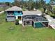 Aerial view of backyard featuring a screened pool, lush lawn and fenced perimeter at 1605 Manor Rd, Englewood, FL 34223