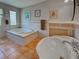 Bathroom with bathtub, sink, neutral tiling, and natural light from glass block window at 1605 Manor Rd, Englewood, FL 34223