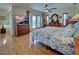 Sunlit bedroom with wood floors, ceiling fan, french doors and a cozy, floral-patterned bedspread at 1605 Manor Rd, Englewood, FL 34223