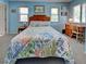 Bedroom with colorful bedspread, blue walls, and dual windows for ample natural light at 1605 Manor Rd, Englewood, FL 34223