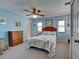 Bedroom with a bed, blue walls, windows, and carpet flooring at 1605 Manor Rd, Englewood, FL 34223