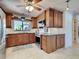 Well-lit kitchen featuring dark wood cabinets, stainless steel appliances and granite countertops at 1605 Manor Rd, Englewood, FL 34223