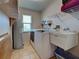 Laundry room with washer, dryer, sink, and storage shelves; window providing natural light at 1605 Manor Rd, Englewood, FL 34223