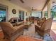 Cozy screened-in patio with wicker furniture, rug, and ceiling fans at 1605 Manor Rd, Englewood, FL 34223