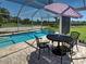 Poolside patio featuring a table and chairs with views of the pool and backyard at 1605 Manor Rd, Englewood, FL 34223