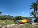 Kayaks on the waterfront with lush greenery and palm trees under a sunny sky at 1605 Manor Rd, Englewood, FL 34223