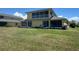 Spacious backyard with lush green grass and a yellow two-story home at 169 Boundary Blvd # 169P, Rotonda West, FL 33947
