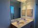 Bathroom featuring double sinks, a granite countertop, wood cabinets and a large framed mirror at 169 Boundary Blvd # 169P, Rotonda West, FL 33947