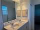 Bathroom featuring double sinks, a granite countertop, wood cabinets and a large framed mirror at 169 Boundary Blvd # 169P, Rotonda West, FL 33947