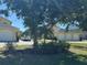 Charming yellow home featuring a three-car garage, a well-manicured lawn, and mature trees at 169 Boundary Blvd # 169P, Rotonda West, FL 33947