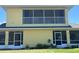 Two-story yellow home with screened in porch and balcony overlooking lawn at 169 Boundary Blvd # 169P, Rotonda West, FL 33947