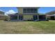Exterior of two-story yellow home with a screened in balcony and large yard at 169 Boundary Blvd # 169P, Rotonda West, FL 33947