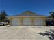 Attached three-car garage with white doors and a wide concrete driveway at 169 Boundary Blvd # 169P, Rotonda West, FL 33947