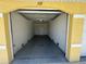 A single car, attached garage with concrete floor, and a doorway into the home at 169 Boundary Blvd # 169P, Rotonda West, FL 33947
