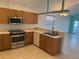 Open concept kitchen with wooden cabinets and stainless steel appliances at 169 Boundary Blvd # 169P, Rotonda West, FL 33947