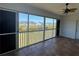 Lanai with large windows, sliding screen doors, and a ceiling fan overlooking the neighborhood pond at 169 Boundary Blvd # 169P, Rotonda West, FL 33947