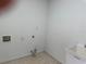 Laundry room with hookups, utility sink, and neutral tile flooring at 169 Boundary Blvd # 169P, Rotonda West, FL 33947