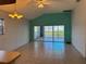 Bright living room with tile flooring, ceiling fan, and sliding door access to screened patio at 169 Boundary Blvd # 169P, Rotonda West, FL 33947