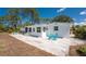 Relaxing backyard with a spa, patio, green grass, and a turquoise patio table set at 1691 Lakeview Pl, Englewood, FL 34223