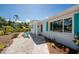 Charming home exterior with stylish turquoise shutters, complimented with colorful landscaping and a cozy seating area at 1691 Lakeview Pl, Englewood, FL 34223
