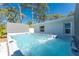 A luxurious hot tub offers a tranquil outdoor experience with a backdrop of tall trees and clear blue skies at 1691 Lakeview Pl, Englewood, FL 34223
