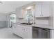 The kitchen features lots of counter space, a stainless steel dishwasher and bright white cabinets at 1691 Lakeview Pl, Englewood, FL 34223